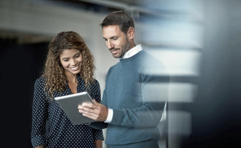 Two people looking at a tablet